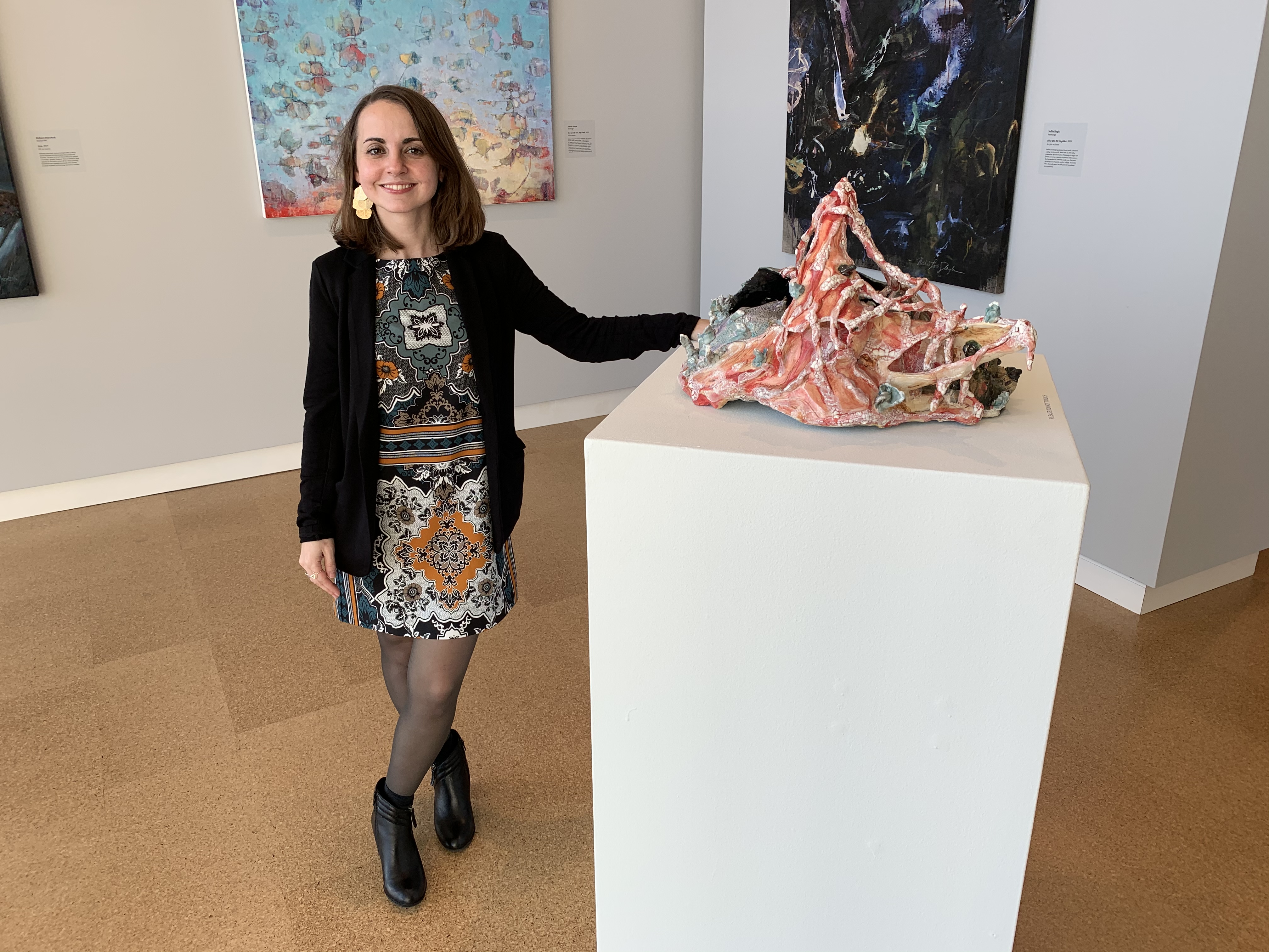 Stephanie Martin with one of her sculptures on a pedestal in a gallery
